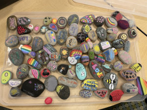 A collection of rocks in various sizes painted with positive messages.